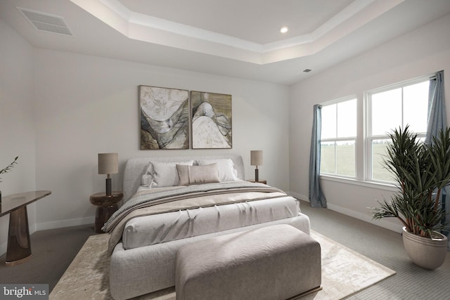 carpeted bedroom featuring baseboards, visible vents, a tray ceiling, and recessed lighting