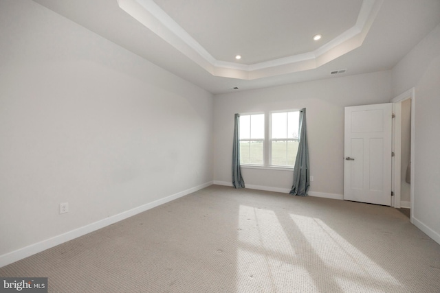 unfurnished room with baseboards, visible vents, a raised ceiling, light colored carpet, and recessed lighting