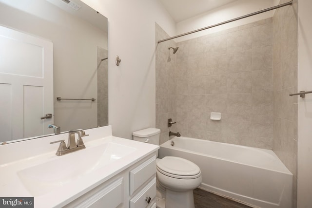 full bath with visible vents, toilet, wood finished floors, vanity, and washtub / shower combination