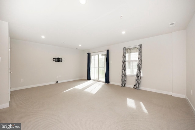 spare room with light carpet, baseboards, and recessed lighting