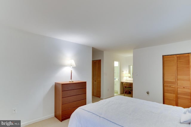 bedroom featuring light carpet, ensuite bath, and baseboards