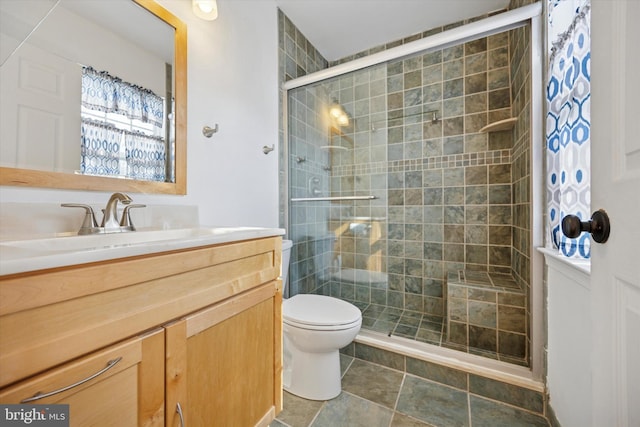 bathroom featuring a stall shower, vanity, and toilet