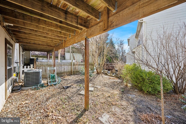 view of yard featuring fence and central AC