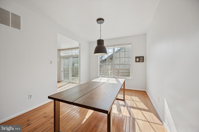 unfurnished dining area with light wood finished floors, baseboards, and visible vents