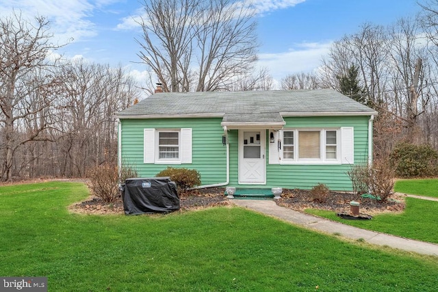 view of front of house featuring a chimney and a front lawn