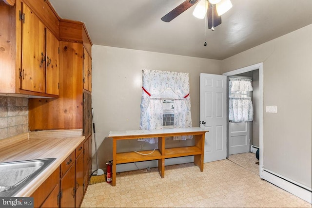 kitchen featuring a baseboard heating unit, light countertops, and brown cabinetry