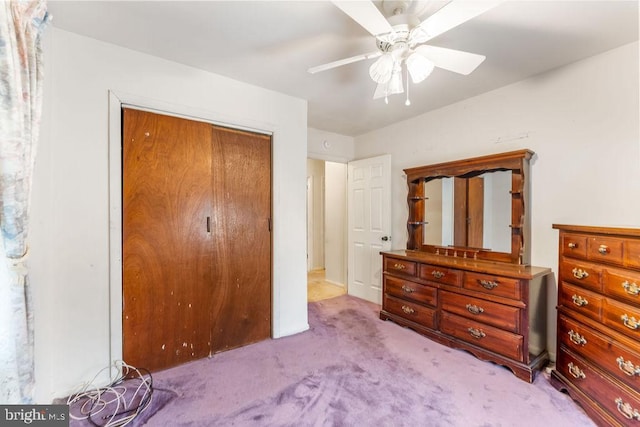 bedroom with a ceiling fan, a closet, and light carpet