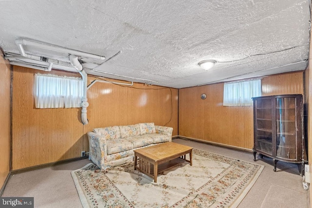 living area featuring wood walls and a textured ceiling