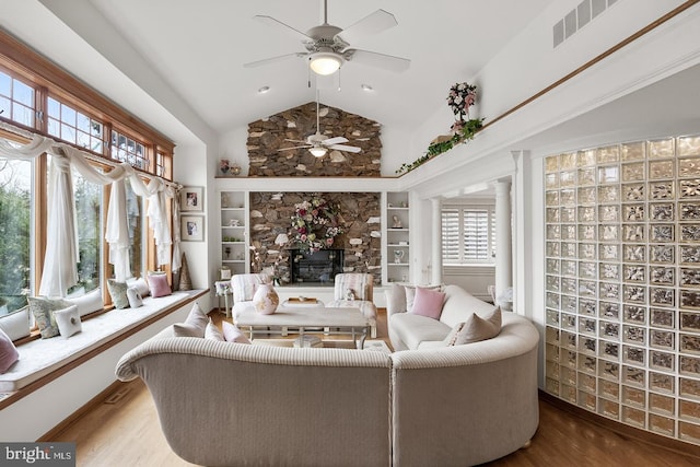 sunroom featuring a fireplace, visible vents, and vaulted ceiling