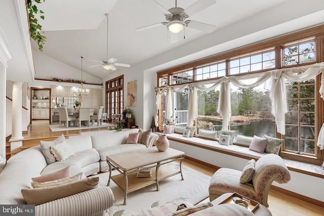 sunroom featuring ceiling fan with notable chandelier, vaulted ceiling, and decorative columns