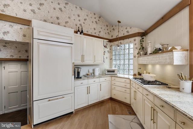 kitchen featuring light wood-style floors, paneled built in fridge, decorative light fixtures, and wallpapered walls