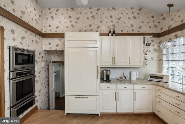 kitchen featuring hanging light fixtures, wallpapered walls, appliances with stainless steel finishes, and open shelves