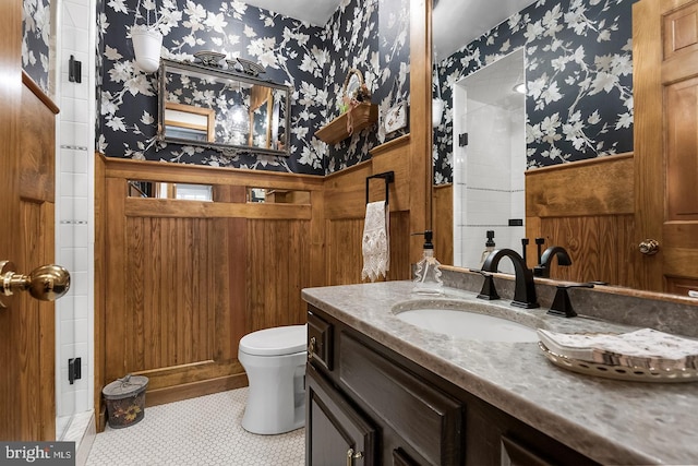 bathroom featuring wallpapered walls, toilet, wainscoting, vanity, and tile patterned floors