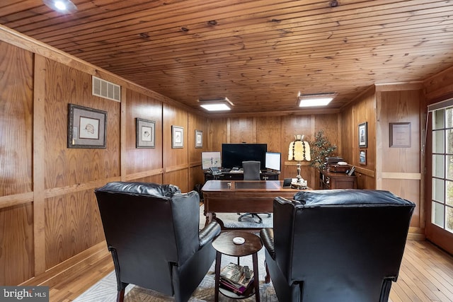 office space with light wood-style floors, wood ceiling, wooden walls, and visible vents