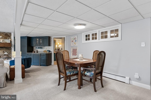 dining room with bar, a baseboard radiator, a paneled ceiling, and light colored carpet