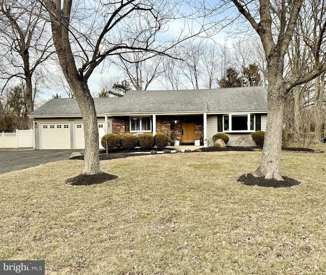 single story home featuring a garage, a shingled roof, fence, driveway, and a front yard