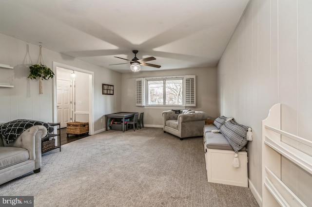 living area with carpet and ceiling fan