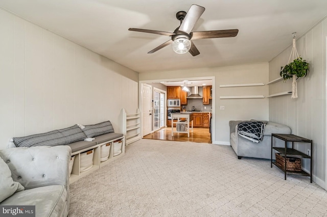 sitting room featuring ceiling fan and baseboards