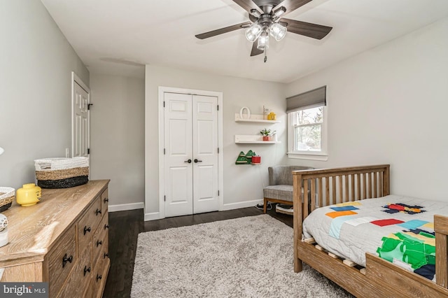 bedroom with a closet, dark wood finished floors, baseboards, and ceiling fan