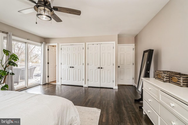 bedroom with baseboards, dark wood finished floors, a ceiling fan, access to outside, and multiple closets