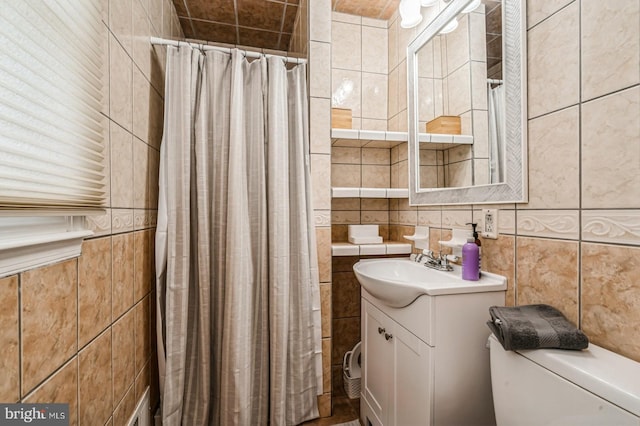 full bath featuring toilet, a shower with curtain, tile walls, and vanity