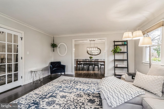 living room with crown molding, baseboards, and wood finished floors