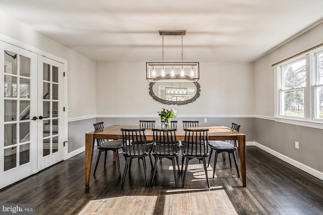 dining space with a chandelier, french doors, wood finished floors, and baseboards