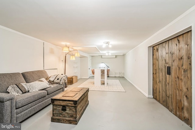 living area with finished concrete flooring, ornamental molding, and baseboards