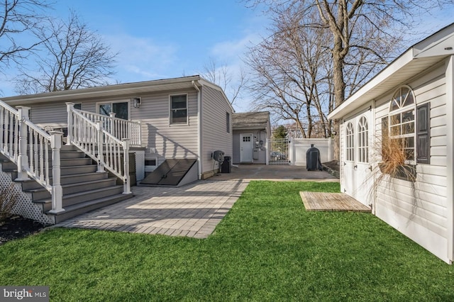 rear view of house with a yard, a gate, stairs, a wooden deck, and a patio area