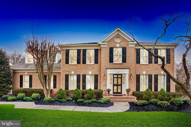 view of front of property featuring brick siding and a front lawn