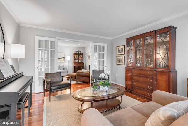 living area featuring ornamental molding, wood finished floors, and baseboards