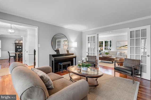 living room featuring a chandelier, crown molding, and wood finished floors