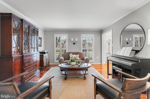 living area with ornamental molding, wood finished floors, and baseboards