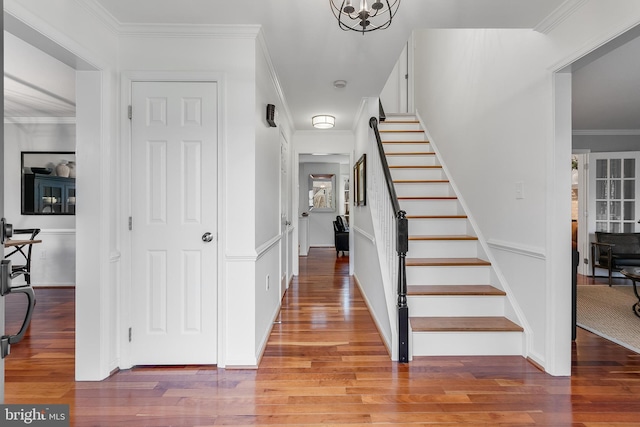 foyer featuring light wood-type flooring, stairs, and crown molding