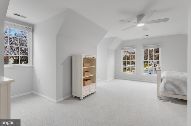 unfurnished bedroom with carpet floors, lofted ceiling, multiple windows, and visible vents