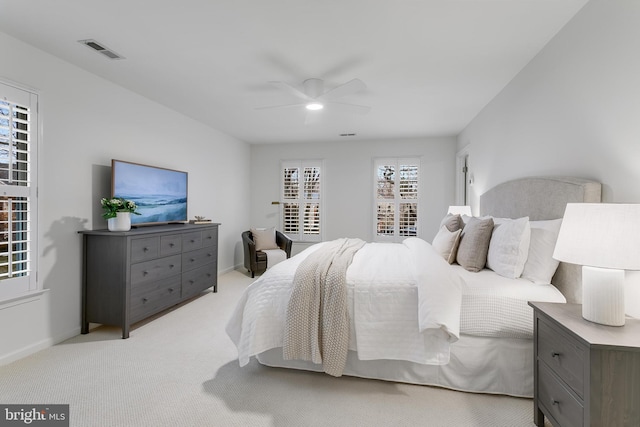 bedroom featuring light carpet, baseboards, visible vents, and a ceiling fan