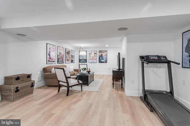 workout room with light wood-type flooring and baseboards