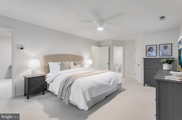 bedroom with visible vents, ensuite bathroom, light carpet, ceiling fan, and baseboards