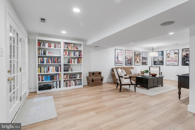 living area featuring baseboards, visible vents, wood finished floors, and recessed lighting