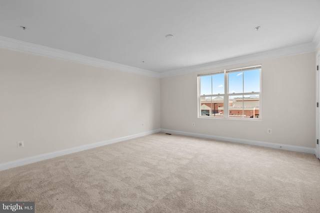 empty room featuring light carpet, baseboards, and crown molding