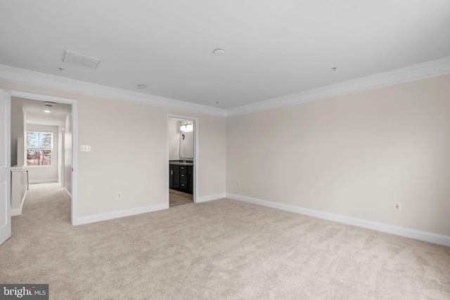 unfurnished bedroom featuring light colored carpet, crown molding, visible vents, and baseboards