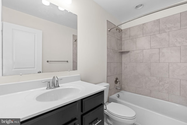 bathroom featuring toilet, vanity, and shower / bathtub combination