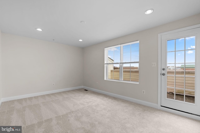 empty room featuring recessed lighting, light colored carpet, visible vents, and baseboards