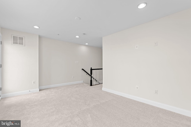 interior space featuring recessed lighting, visible vents, light carpet, and baseboards