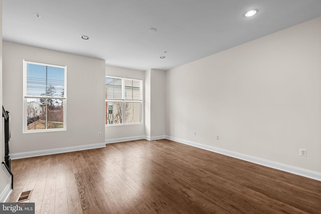 unfurnished room featuring visible vents, baseboards, wood finished floors, and recessed lighting