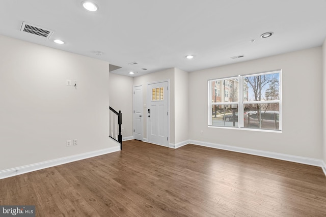 interior space with stairs, dark wood-style floors, visible vents, and baseboards