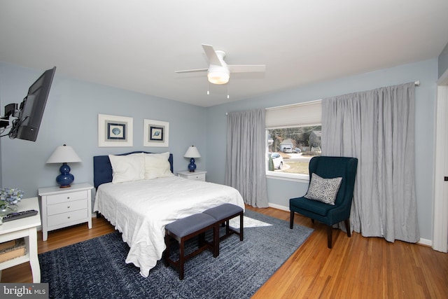 bedroom with ceiling fan, baseboards, and wood finished floors