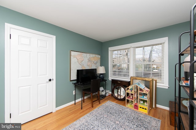 office space with baseboards and wood finished floors