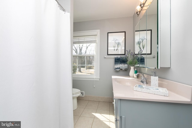 bathroom with toilet, vanity, baseboards, and tile patterned floors