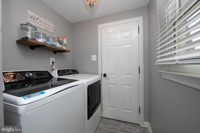 laundry area featuring baseboards, laundry area, washing machine and clothes dryer, and light wood-style floors